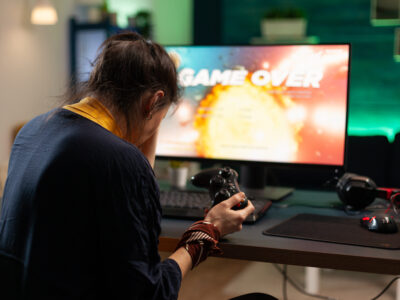 Angry woman playing online video games with joystick; Combating Gaming Disorder in Teens