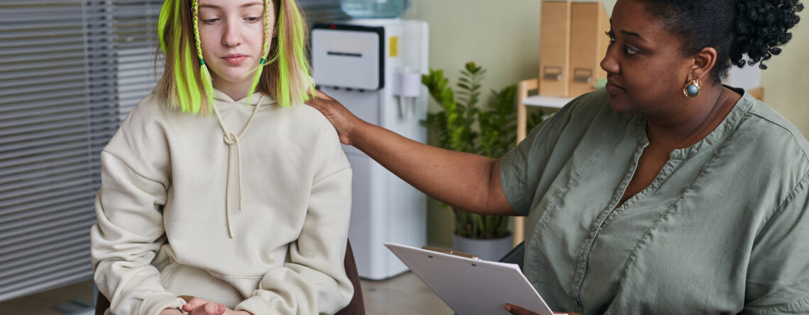 Teenage girl sitting on chair and talking with specialist giving her an advice during treatment. Marijuana and Mental Health: The Psychosis Connection