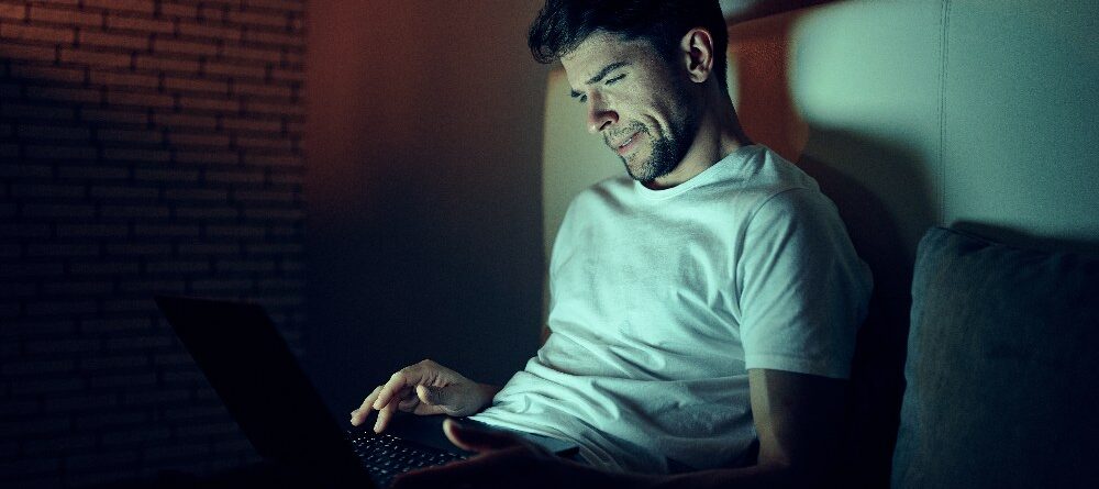 Man Works Late on Laptop in his Room